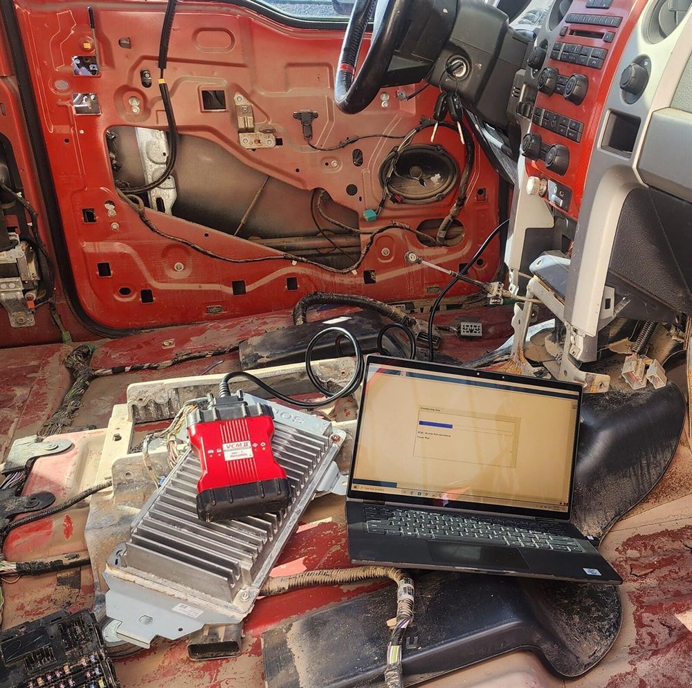 Control module removed from a Ford truck and connected to a laptop for reprogramming
